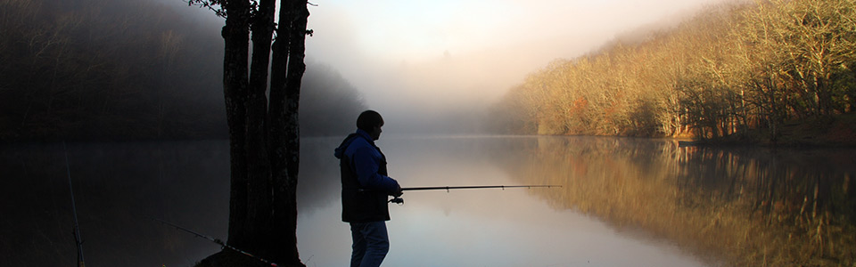 Pêcheur sur une rivière brumeuse à Cheissoux